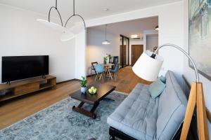 a living room with a couch and a tv at Riga Riverside Spacious One Bedroom Apartment in Rīga