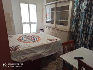 Zimmer mit einem Bett, einem Tisch und einem Fenster in der Unterkunft La Casa di Nonna Marianna in Polignano a Mare