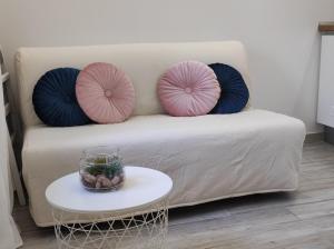 two pink and blue pillows on a couch with a table at Rooms Mali Raj in Zaton