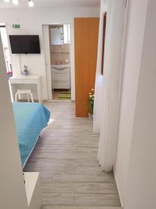 um corredor de um quarto com uma cama e uma casa de banho em Rooms Mali Raj em Zaton