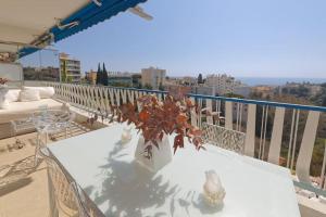 un vase blanc avec une plante sur une table sur un balcon dans l'établissement CANNES Vue Mer, à Cannes