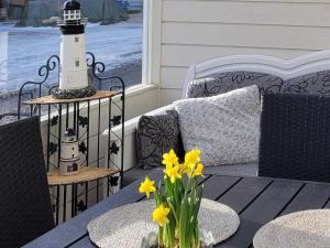 a porch with a lighthouse and a table with flowers at Rantahiekka B4 in Kalajoki