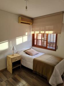 1 dormitorio con 2 camas y ventana en Casa Carrasco, en Montevideo