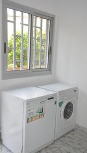 a washing machine in a room with a window at Villa les 3 oisillons in Kribi