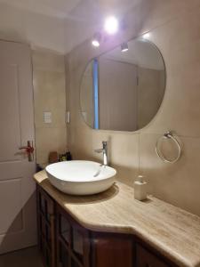 a bathroom with a sink with a large mirror at Casa Carrasco in Montevideo