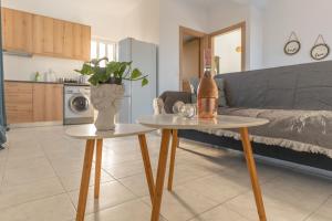 a living room with a couch and a table with a bottle at Marvinas seaside apartments, GAIA apartment & HYDOR jacuzzi apartment in Kremasti