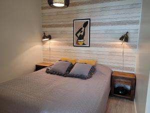 a bedroom with a bed and a wooden wall at Rantahiekka B4 in Kalajoki