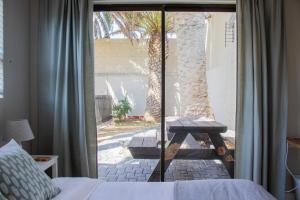 a bedroom with a bed and a sliding glass door at Avodation in Walvis Bay