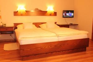 ein Bett in einem Schlafzimmer mit zwei Lichtern an der Wand in der Unterkunft Ferienwohnung Schwarzwald in der Pension Glöcklehof in Todtnau