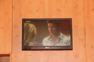 Ein Fernseher an der Wand mit einem Mann und einer Frau in der Unterkunft Ferienwohnung Schwarzwald in der Pension Glöcklehof in Todtnau