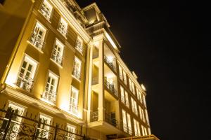 a large yellow building with lit windows at night at VIZUALIZA Residence Hotel in Plovdiv