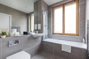 a bathroom with a toilet and a sink and a tub at Designer Penthouse Notting Hill with Terrace sleeps Five in London