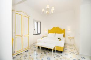 a white bedroom with a large bed and a chandelier at Casale Guarracino in Sant'Agnello