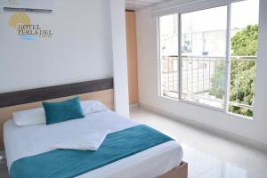 a bedroom with a bed and a large window at Hotel Perla del Caribe in Santa Marta