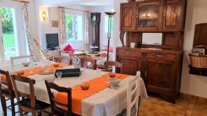 comedor con mesa con sillas y TV en Saint Georges de Didonne - MAISON avec jardin clos - PROCHE COMMERCES, en Saint-Georges-de-Didonne