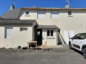 uma casa com uma mesa de madeira em frente em location appartement 100 m de la plage em Pénestin