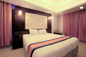 a bedroom with a large bed with pink curtains at Cox Beach Resort in Cox's Bazar