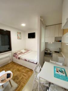 a small room with a bed and a table at Apartman Kata in Zlatibor