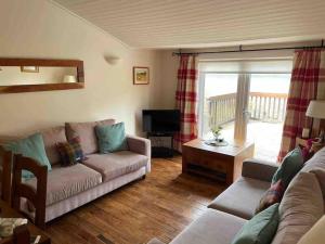 a living room with a couch and a tv at Viking Cottage in Arrochar