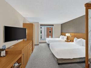 Habitación de hotel con 2 camas y TV de pantalla plana. en Hyatt Place Champaign/Urbana, en Champaign