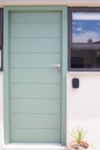 una puerta verde de garaje en una casa con ventana en Avodation en Walvis Bay