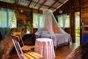 a bedroom with a bed and a table in a room at Playa Grande Lodge in Cahuita
