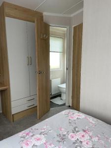 a bedroom with a bed and a bathroom with a toilet at Swift Bordeaux in Dunoon