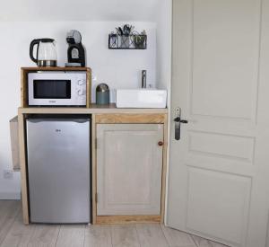 a kitchen with a microwave and a refrigerator at La Cabane in Penne-dʼAgenais