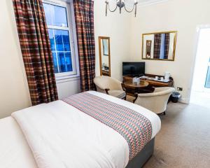 a bedroom with a bed and a desk with a computer at Grampian Hotel in Perth