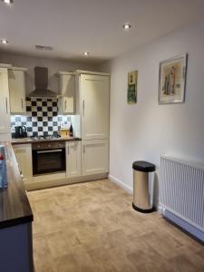 a kitchen with white cabinets and a tile floor at Modern 3 bedroom semi detached home in Limavady