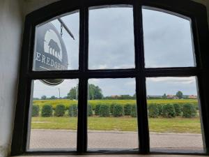 una ventana con vistas a un campo de cultivos en De Beredoezen - sfeervolle vakantiewoning in de gezellige Kempen en Retie