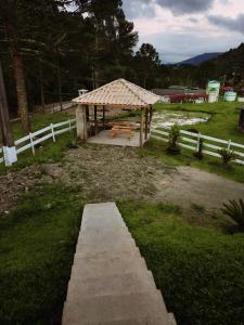 un refugio de picnic con un banco en un patio en Casa de Campo Machado, en Urubici