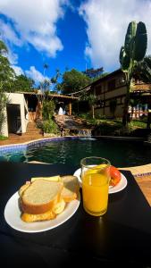 einen Tisch mit einem Teller Toast und einem Glas Orangensaft in der Unterkunft Estância Peti in Barão de Cocais