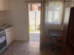 a kitchen with a door open to a kitchen with a table at Lepihue II in Puerto Montt