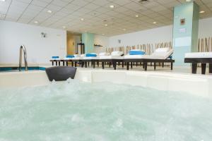 una gran piscina de agua en una habitación con sillas en Costa del Sol Wyndham Lima Airport, en Lima