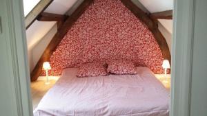 a bed with a red headboard in a room at Domaine d'Antigneul in Bours
