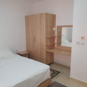 um quarto com uma cama e um espelho em RESIDENCE OUARZAZATE em Uarzazate