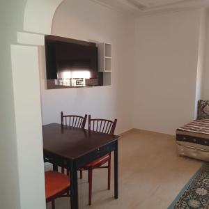 uma sala de jantar com mesa e cadeiras e uma televisão em RESIDENCE OUARZAZATE em Uarzazate