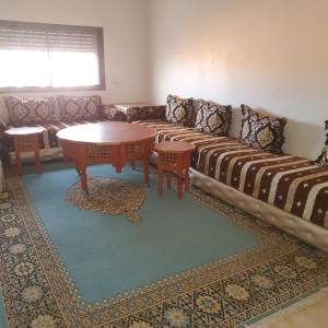 ein Wohnzimmer mit einem Sofa und einem Tisch in der Unterkunft RESIDENCE OUARZAZATE in Ouarzazate