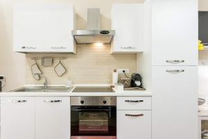 パレルモにあるCATHEDRAL APARTMENTの白いキャビネットとシンク付きのキッチン