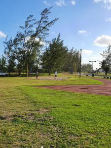 a group of people playing baseball in a park at Pousada Astúrias in Ilha Comprida