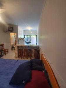 a bedroom with a bed and a kitchen with a counter at Pousada Astúrias in Ilha Comprida