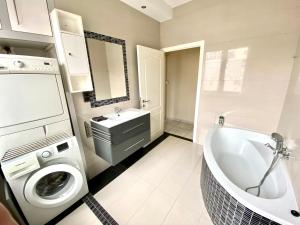 ein Badezimmer mit einer Waschmaschine und einem Waschbecken in der Unterkunft Central Park Apartments in Antwerpen
