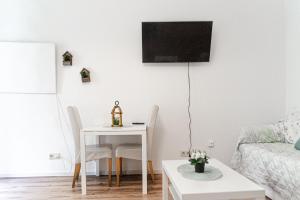 sala de estar con mesa y TV en la pared en Charming Apt - ideal for Longstays, en Viena