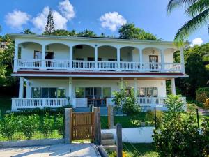 a large white house with a wrap around porch at VILLA COLIBRI in Mon Repos