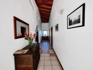 un pasillo con un jarrón de flores sobre una mesa en VILLA COLIBRI, en Mon Repos