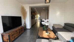 a living room with a large flat screen tv at Mini villa chaleureuse avec vue mer imprenable in San-Nicolao