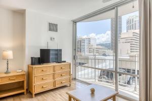 a living room with a tv and a large window at Ilikai 883 in Honolulu