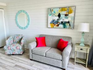 a living room with a couch and a chair and a mirror at 354 Beach Daze Oceanfront Great Location in Myrtle Beach