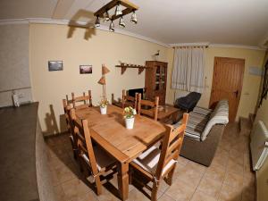 a dining room with a wooden table and a couch at Casa Rural Guadiela in San Pedro Palmiches